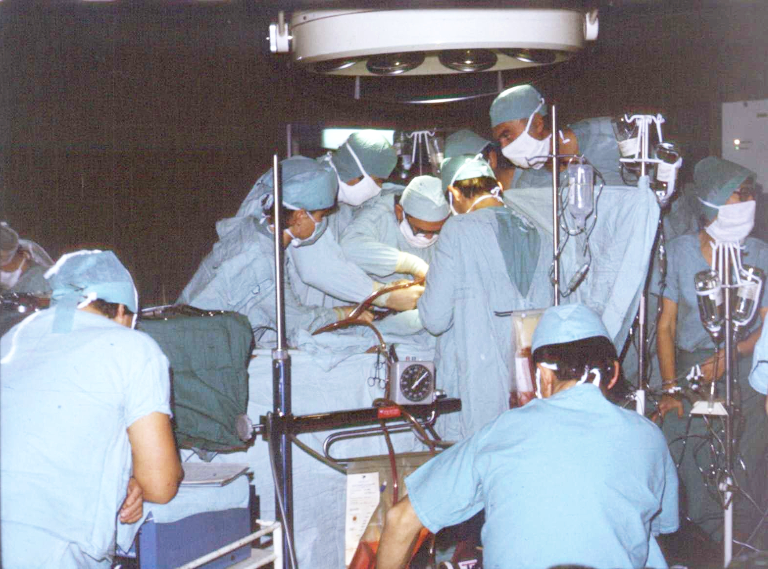 Historyczne zdjęcie z sali operacyjnej. Medycy przy stole operacyjnym podczas operacji.